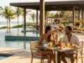 Família em resort à beira-mar avaliando se pacote all inclusive vale a pena para a viagem