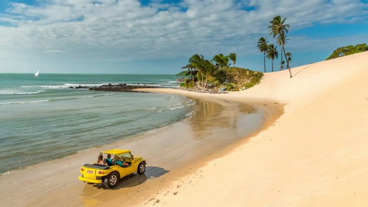 Vista aérea de uma das melhores praias do Rio Grande do Norte com mar azul, falésias e coqueiros