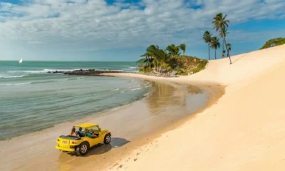 Vista aérea de uma das melhores praias do Rio Grande do Norte com mar azul, falésias e coqueiros