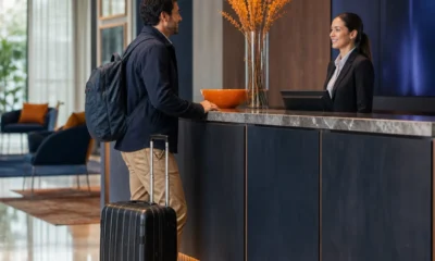 Como funciona o early check-in no hotel e quando ele pode ser cobrado - destacada: Hóspede fazendo early check-in no balcão de um hotel