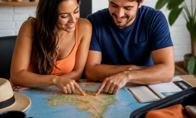 Lugares baratos para viajar em novembro: destinos e estratégias para economizar - destacada: Casal planejando lugares baratos para viajar em novembro com mapa e mala de viagem