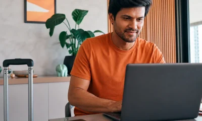 destacada: Passageiro pesquisando o que são pontos qualificáveis Azul em um notebook antes de planejar uma viagem