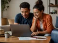 É possível parcelar reserva de hotel? Veja o que conferir antes de pagar - Casal planejando uma reserva de hotel parcelada no notebook