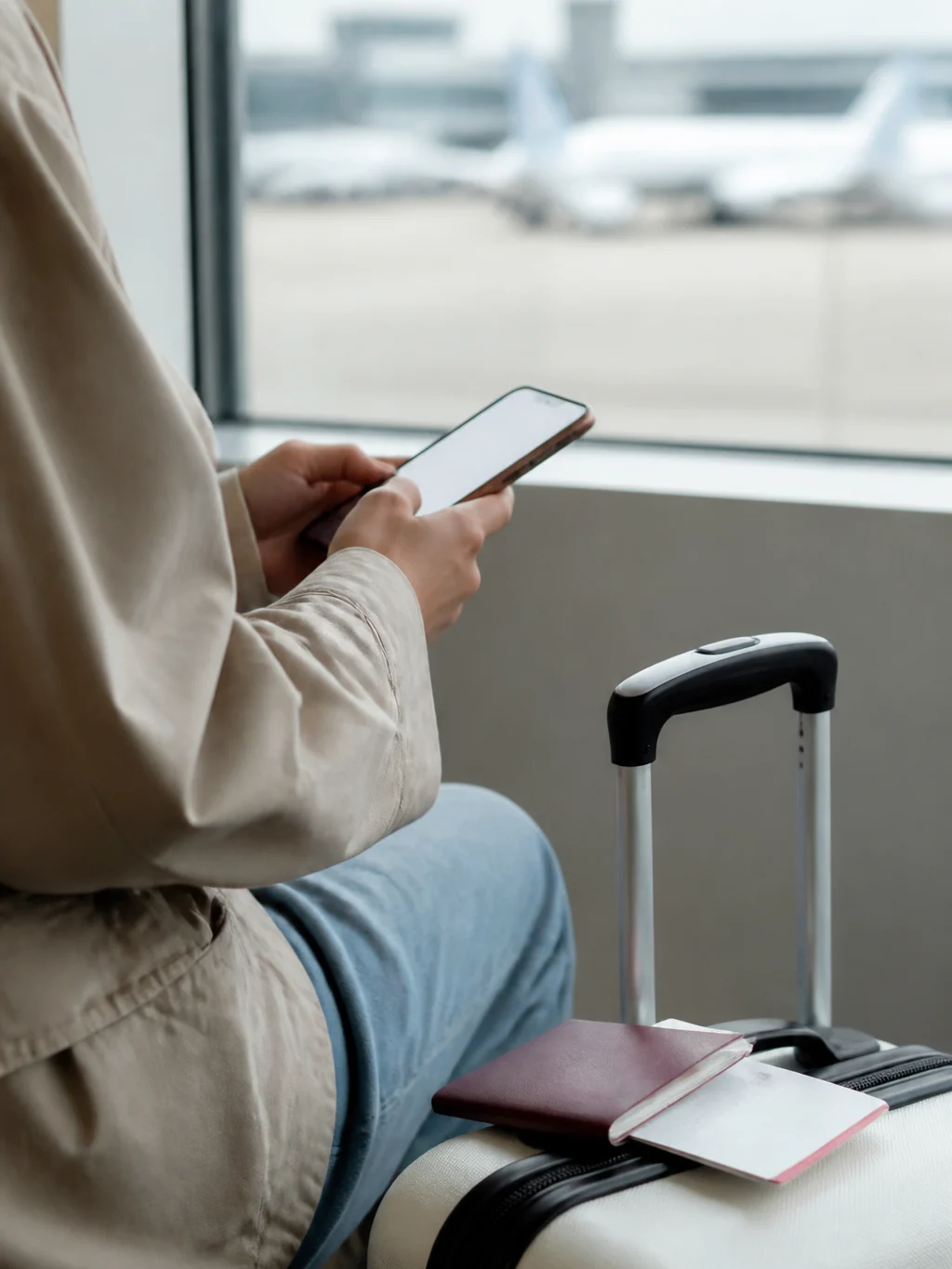 O que conferir antes de comprar passagem aérea e evitar erros - Viajante conferindo dados antes de comprar passagem aérea pelo celular