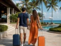 Pacote de viagem para resort: o que conferir antes de reservar - destacada: Casal chegando a um resort de praia para férias com pacote de viagem