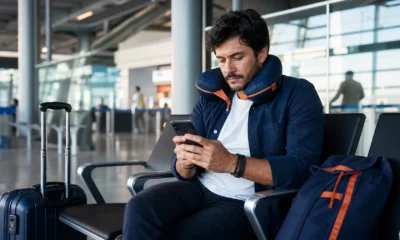 Passagem aérea flexível vale a pena? Compare regras antes de comprar - Viajante analisando opções de passagem aérea flexível no aeroporto