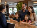Cama extra no hotel: quando é possível pedir e o que conferir antes - Família consultando a possibilidade de cama extra no hotel em um quarto de hospedagem