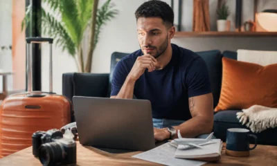 Como emitir passagem Smiles e comparar milhas, taxas e dinheiro - Passageiro pesquisando como emitir passagem Smiles em notebook antes de uma viagem