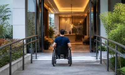 Como escolher hotel acessível e confirmar adaptações antes da reserva - Hóspede cadeirante entrando em hotel acessível com rampa na entrada