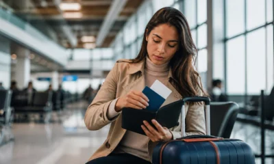 Documentos para viajar de avião no Brasil: o que levar ao aeroporto - Passageira organizando documentos para viajar de avião no Brasil antes do embarque