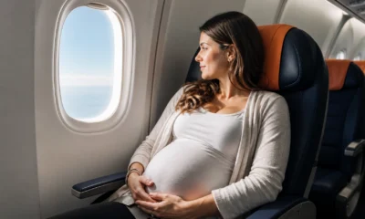 Gestante pode viajar de avião? Cuidados, documentos e limites - Gestante sentada próxima à janela de um avião durante viagem