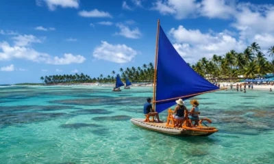 O que fazer em Porto de Galinhas além das piscinas naturais - Vista aérea das piscinas naturais de Porto de Galinhas com jangadas e mar azul