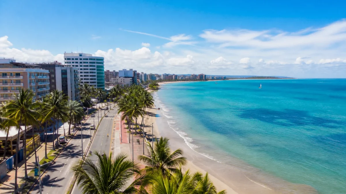Onde ficar em Maceió: compare Pajuçara, Ponta Verde e outras regiões - Vista da orla de Maceió com hotéis, coqueiros e mar azul
