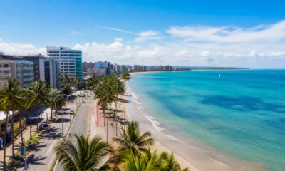 Onde ficar em Maceió: compare Pajuçara, Ponta Verde e outras regiões - Vista da orla de Maceió com hotéis, coqueiros e mar azul